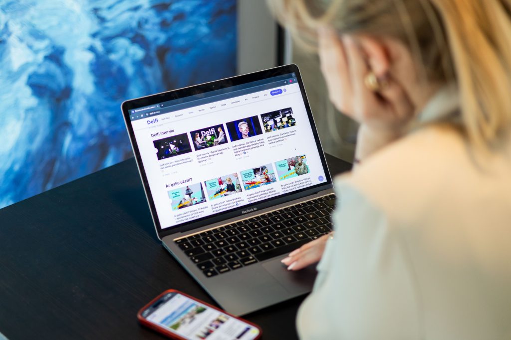 Mergina žiūrinti į nešiojamojo kompiuterio ekraną